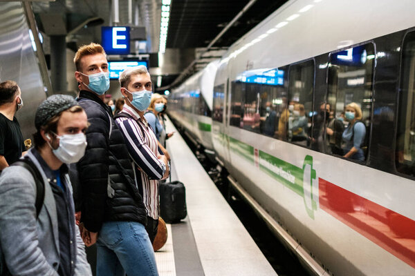 Berlin, Germany - July, 2020: People wearing mask waiting for ICE train on platform at station( Berlin Hauptbahnhof)