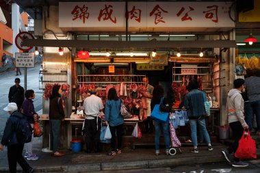 Hong Kong, Çin - Kasım 2019: Kasap Hong Kong 'da sokak marketlerinde insanlara et satıyor