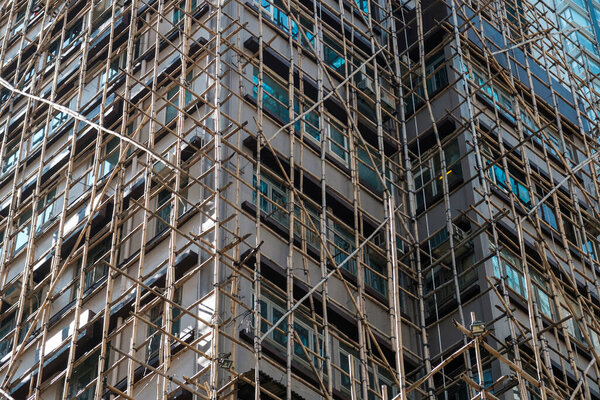 Bamboo scaffolding on building facade, bamboo pole framework,