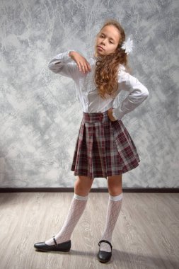 Liseli kızlar okul üniformalı teşkil etmektedir ve eğlenceli bir ışık gri arka plan üzerinde vardır. Okula dönüş. Yeni öğretim yılı. Çocuk eğitim kavramı.