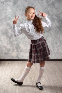 Liseli kızlar okul üniformalı teşkil etmektedir ve eğlenceli bir ışık gri arka plan üzerinde vardır. Okula dönüş. Yeni öğretim yılı. Çocuk eğitim kavramı.