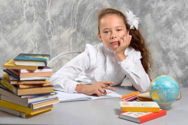 Skolflickas Skoluniform Sitter Vid Skrivbordet Och Tycker Beslut Uppgiften Grå — Stockfoto