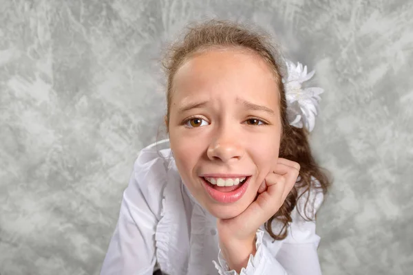 Kız öğrenciler okulda bir masada oturan ve komik bir surat üniforma. Geniş açı çekim. Okula dönüş. Yeni öğretim yılında. Bir çocuğun eğitim kavramı.