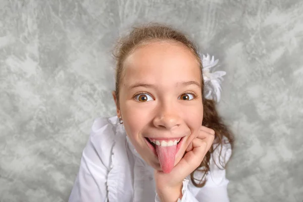 Kız öğrenciler okulda bir masada oturan ve komik bir surat üniforma. Geniş açı çekim. Okula dönüş. Yeni öğretim yılında. Bir çocuğun eğitim kavramı.