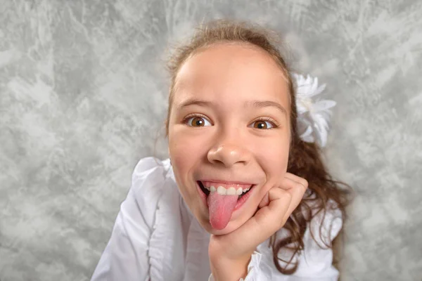 Kız öğrenciler okulda bir masada oturan ve komik bir surat üniforma. Geniş açı çekim. Okula dönüş. Yeni öğretim yılında. Bir çocuğun eğitim kavramı.