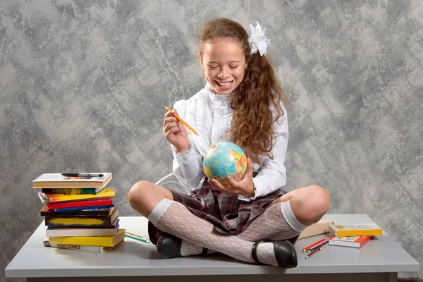 Colegiala Inquieta Uniforme Escolar Sienta Mesa Sonríe Felizmente Sobre Fondo — Foto de Stock