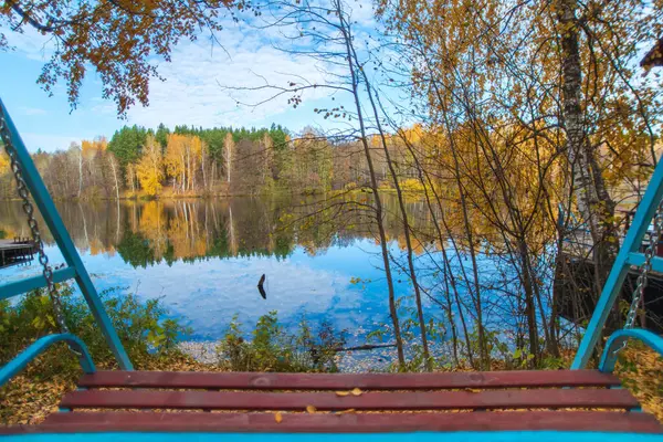 秋千位于湖滨的森林里 秋天的蓝色湖上 黄树成荫 景色壮观极了 — 图库照片