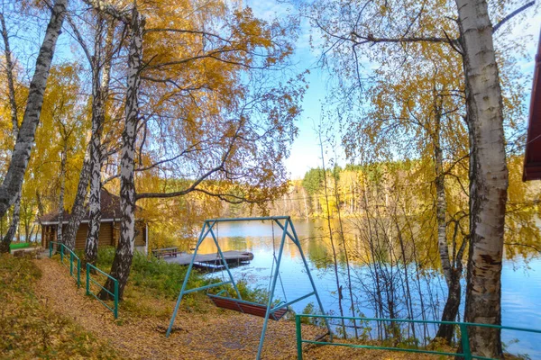 秋千位于湖滨的森林里 秋天的蓝色湖上 黄树成荫 景色壮观极了 — 图库照片