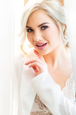 Peignoir'da güzel bir gelin. Güzel genç kız. Lüks uzun kıvırcık saçlı sarışın kadın. Gelinin Boudoir sabahı.