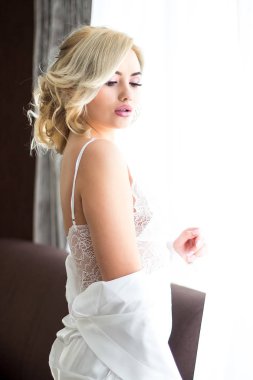 Güzel makyaj ve saç modeli beyaz sabahlık poz ile genç sarışın kız