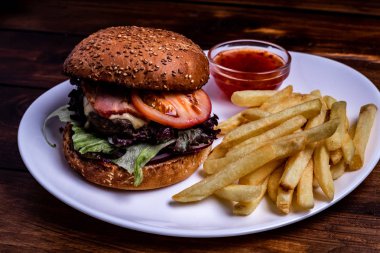 Çizburger kapatın. Burger sebze ve patates kızartması. Vintage rustik tarzı.