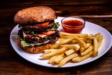 dana pirzola ahşap bir masa, yakın çekim koyu arka plan üzerinde yakın çekim burger