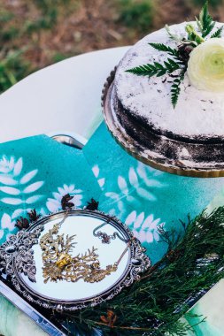 Çiçekler ve süslemeleri küçük bir tablo üzerinde çevrili şeker krema ile sünger kek tozunu