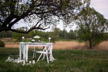 Düğün masa bir kek ve bir alanda duran mum.