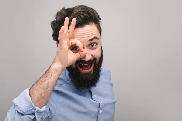 Улыбающийся парень показывает ОК жест перед камерой — стоковое фото