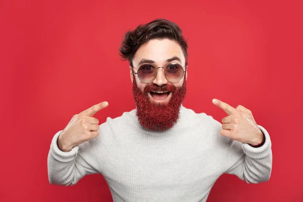 Возбужденный хипстер, указывающий на светящуюся бороду — стоковое фото