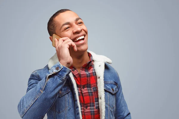 Веселый этнический мужчина говорит по телефону — стоковое фото