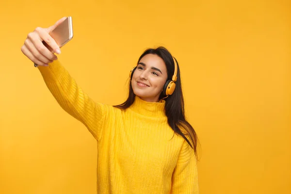 Chica sonriente en auriculares tomando selfie — Foto de Stock