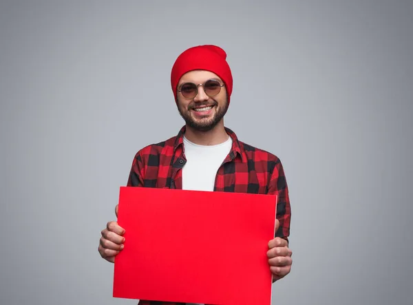 Стильный парень показывает пустую красную бумагу — стоковое фото