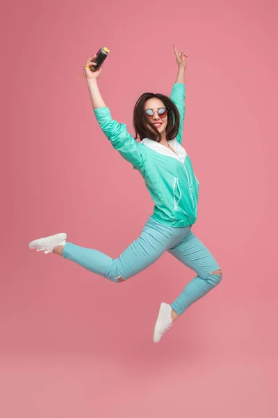 手にカメラで流行に敏感な女の子をジャンプ — ストック写真