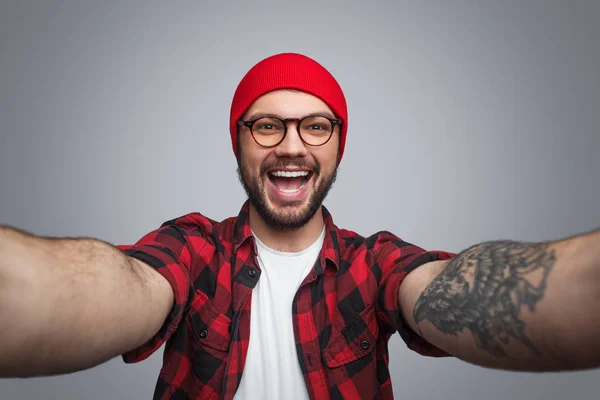 Aufgeregter Trendmann macht Selfie auf Grau — Stockfoto