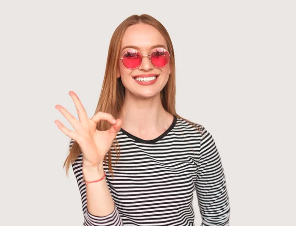 Menina na moda mostrando gesto OK no branco — Fotografia de Stock