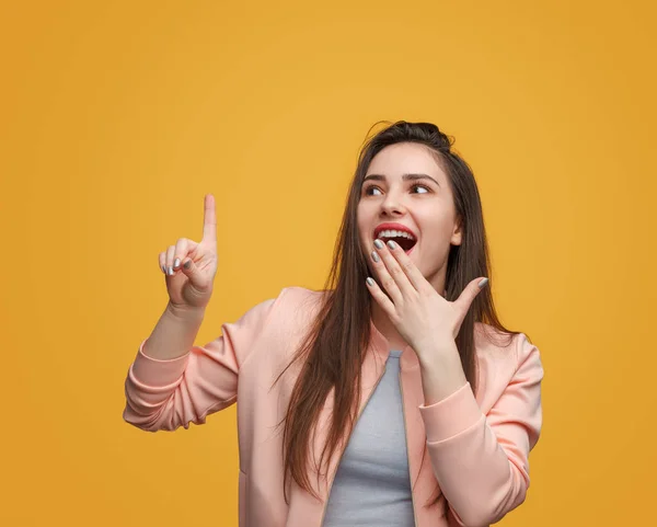 Shocked girl touching invisible interface on orange — Stock Photo, Image