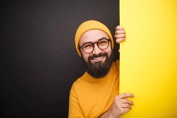 Сміється хлопець в окулярах з жовтим плакатом — стокове фото