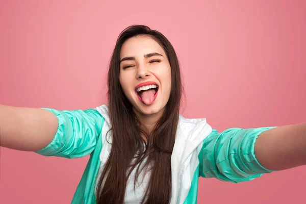 Jovem mulher mostrando língua no estúdio — Fotografia de Stock