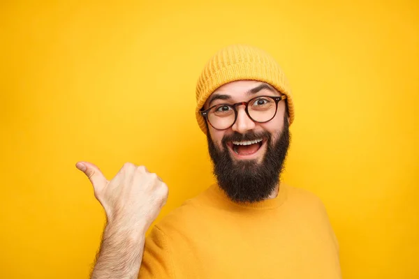 Colorido homem da moda apontando para longe no amarelo — Fotografia de Stock