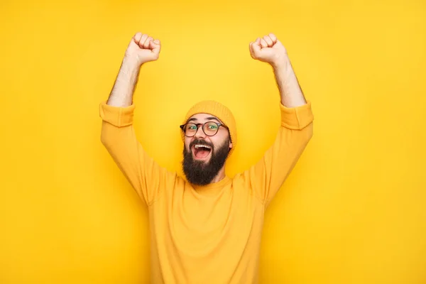 Happy man in yellow with hands up — Stock Photo, Image