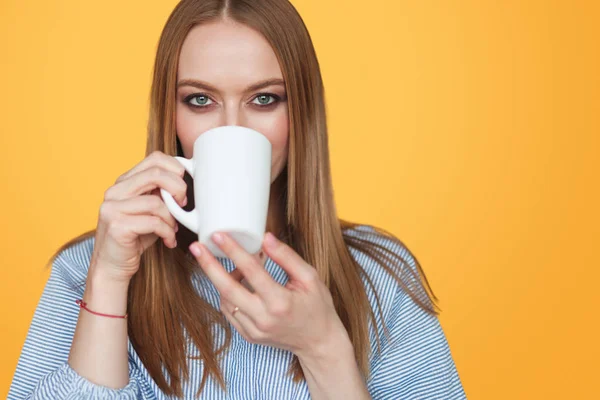 Hermosa mujer bebiendo de la taza en el estudio —  Fotos de Stock