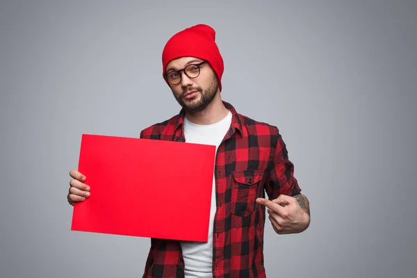 Νεαρός άνδρας που δείχνει σε κόκκινο αφίσα — Φωτογραφία Αρχείου