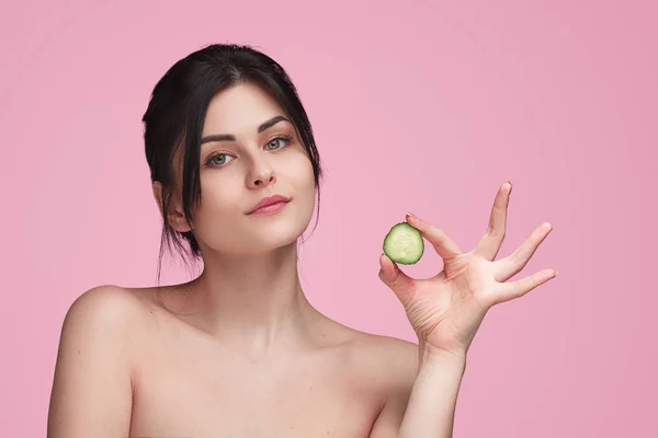 Feminino com fatia de pepino em estúdio — Fotografia de Stock