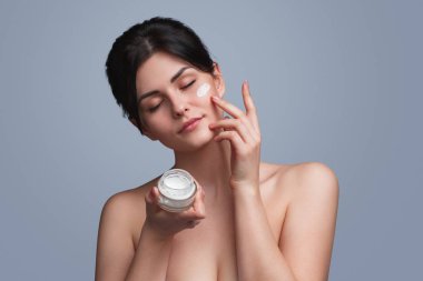 Şehvetli kadın nemlendirici krem uygulamak