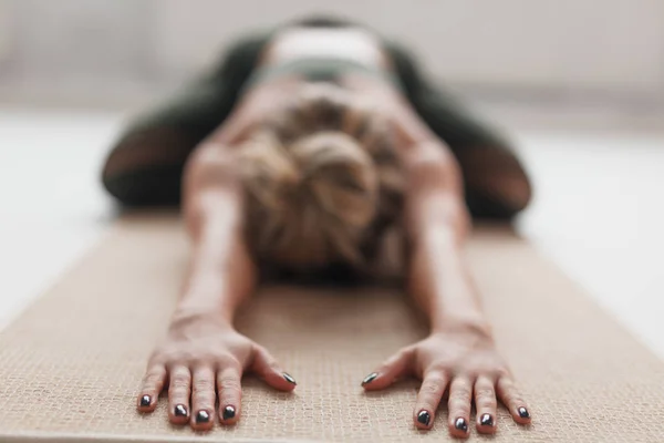 Анонімна жінка тягнеться на йога килимок — стокове фото