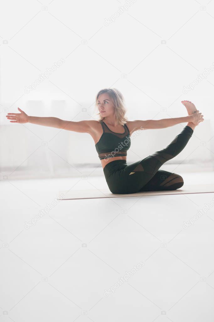 Confident woman training yoga on mat