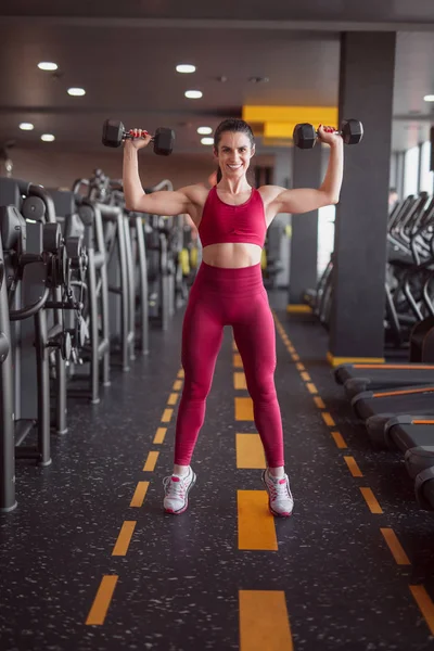 Sorrindo esportista treinando com halteres — Fotografia de Stock