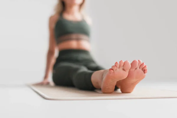 Размытая женщина сидит на коврике для йоги — стоковое фото