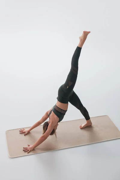 Woman practicing yoga asana on mat — Stock Photo, Image