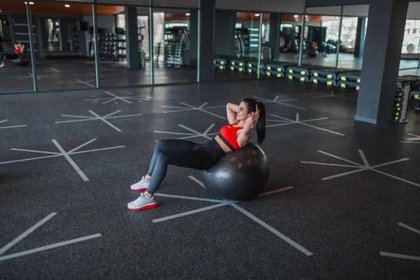 Mulher alegre fazendo abdominais crunches na bola de exercício — Fotografia de Stock