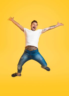 Etkileyici adam sarı zemin üzerinde atlama