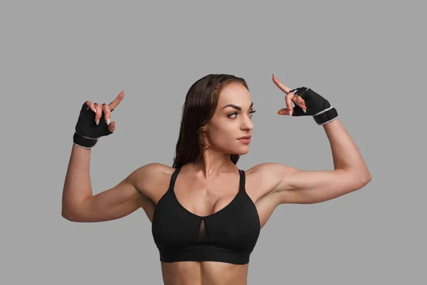 Muskulös kvinna pekar uppåt — Stockfoto