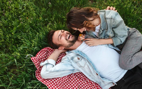 Genç çift çimenlerin üzerinde gülüyor — Stok fotoğraf