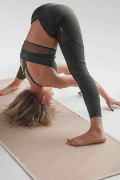 Mulher em sportswear formação asana no tapete — Fotografia de Stock