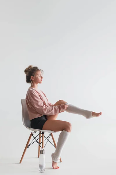 Vrouw op stoel beenkappen te zetten — Stockfoto