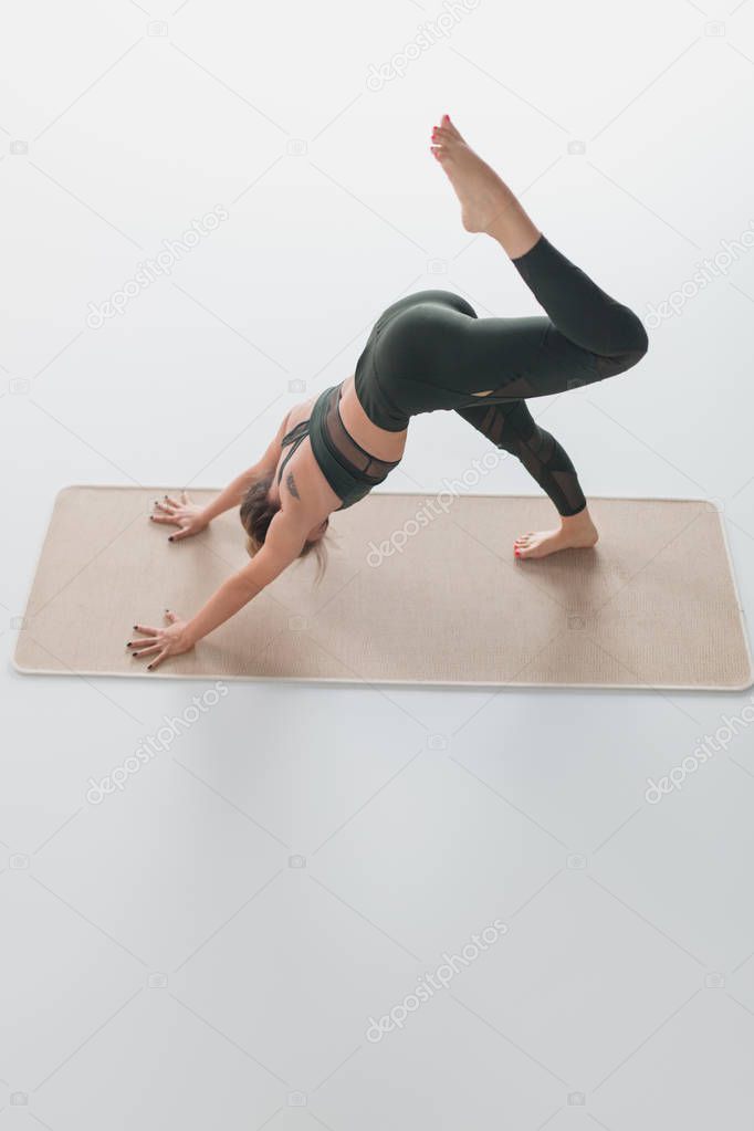 Slim woman in sportswear practicing yoga