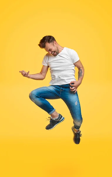 Mann springt und spielt imaginäre Gitarre — Stockfoto