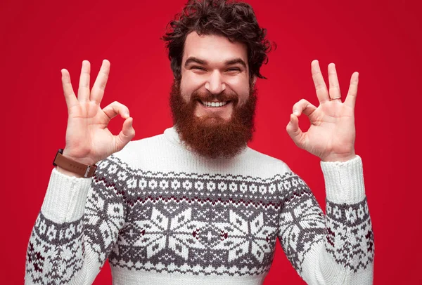 Pozitív férfi szakállal ok gesztus mutatja a piros hátteret — Stock Fotó