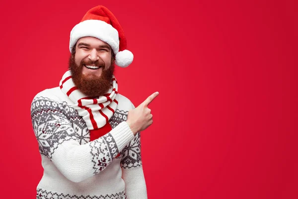 Homem em roupas de Natal apontando para longe copyspace isolado sobre vermelho — Fotografia de Stock